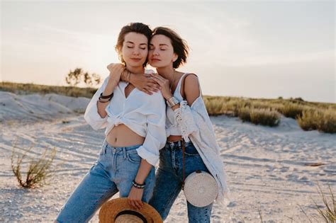 Duas mulheres bonitas se divertindo na praia do pôr do sol romance de amor lésbico gay Foto