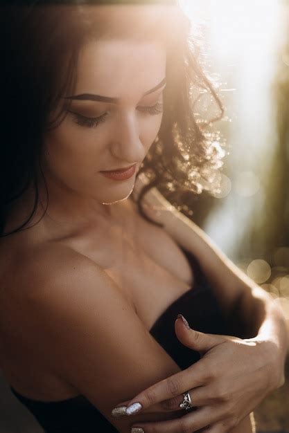 Free Photo Gorgeous Brunette Woman In Black Dress Holds Hands On Her Shoulders