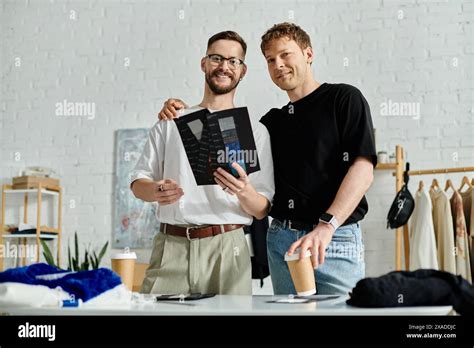 A Gay Couple Designers In Love Stand Triumphantly Next To Each Other In Their Workshop Stock