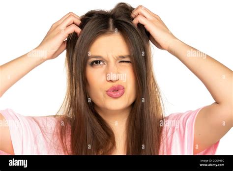 Portrait Of Young Nervous Woman Scratches Her Head On White Background