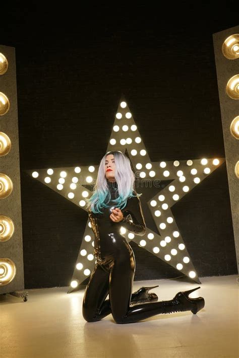 Hot Slim Woman Posing In Latex Rubber Fashion Clothes On Black Background With Yellow Lights