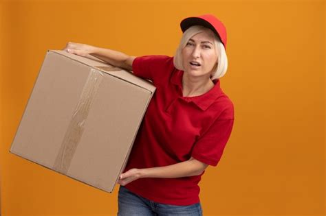 Livreuse Blonde D âge Moyen Tendu En Uniforme Rouge Et Casquette Tenant Une Boîte En Carton