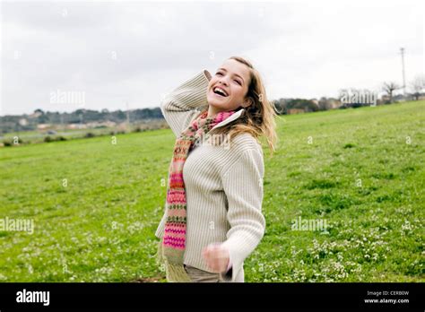 Female Long Blonde Hair Wearing Cream Jumper Over Pink Jumper Biege Cords Field In Background