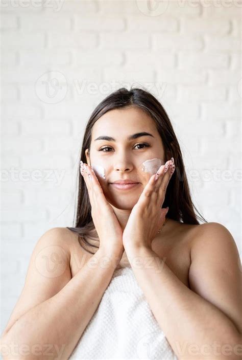 Woman Wearing Bathrobe Applying Facial Cream On Her Face 3349228 Stock