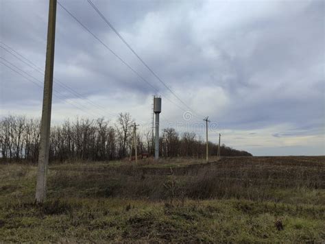 Agricultural Field Electric Poles And Water Tower In Winter Stock Photo