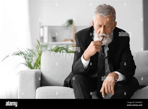 Thoughtful Mature Man Sitting On Sofa In Office Stock Photo Alamy