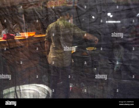 Bangladeshi man cooking hidden behind a curtain during ramadan fast ...