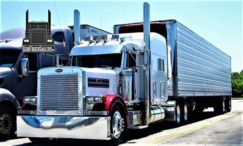 Two Large Semi Trucks Are Parked On The Side Of The Road With Trees In