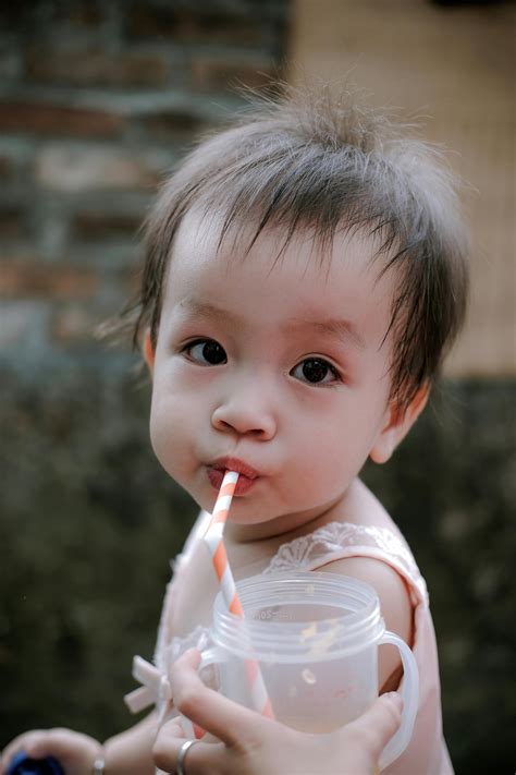 A Baby Drinking From a Coconut · Free Stock Photo