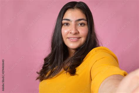 Beautiful Latina Woman Taking A Selfie In Studio With Pink Background Chubby Woman Stock Photo