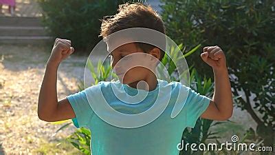 Le Petit Garçon Bronzé Gay Dans Un T shirt Bleu Affiche Son Muscle Biceps Banque De Vidéos