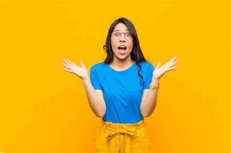 Joven mujer bonita latina sintiéndose sorprendida y emocionada riendo asombrada y feliz por