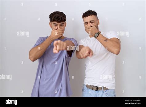 Homosexual Gay Couple Standing Over White Background Laughing At You Pointing Finger To The