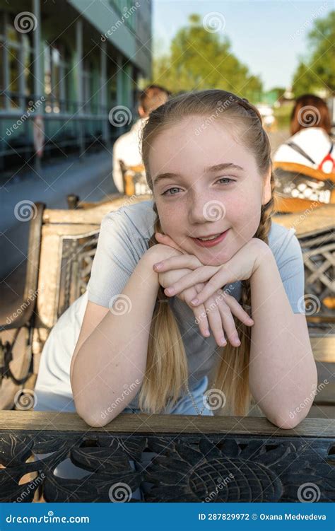 Portrait Of A Beautiful Girl Of 14 Years Old With Long Blonde Hair The Girl With Braids Looks