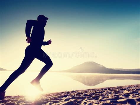 Man Exercising On Beach Silhouette Of Active Man Exercising And