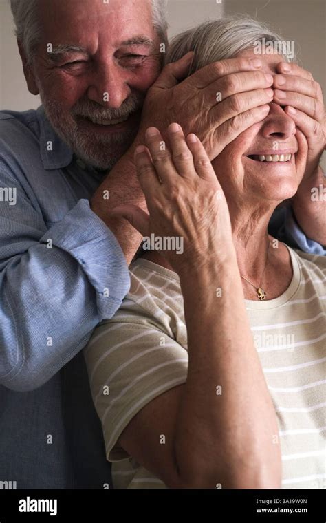 Elderly Husband Surprises His Mature Wife By Covering Her Eyes With His Hands And Hugging Her