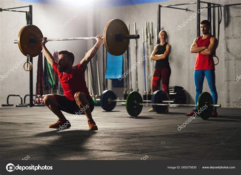 Man Squatting And Lifting A Barbell Stock Photo By Santypan 565375830