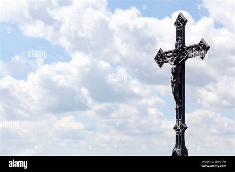 Metal Christian Cross On Blue Cloudy Sky Background Copy Space