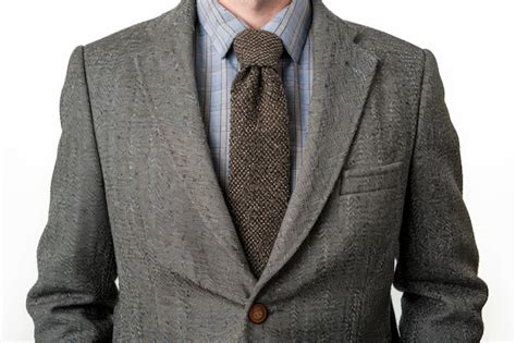 A Closeup Of A Mans Suit Jacket And Necktie Against A White Background