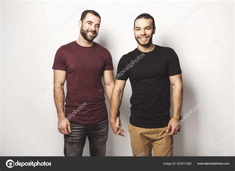 Jóvenes homosexuales pareja gay amor entre sí en un fondo blanco fotografía de stock Lopolo