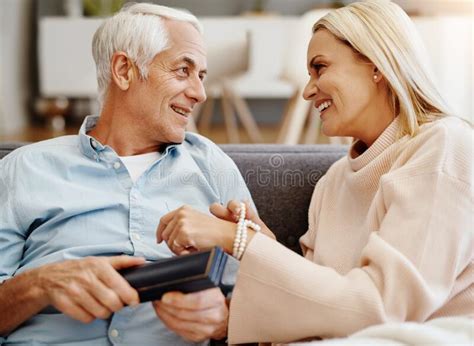 Money Cant Buy Happiness But It Can Buy Jewelry Mature Man Giving His Wife A Gift On The Sofa