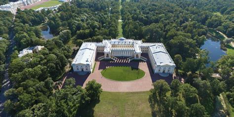 An Aerial View Of A Large Building In The Middle Of A Park With Trees