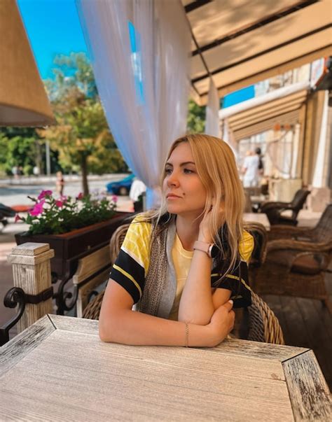 Premium Photo Caucasian Blonde Girl In A Tshirt Sitting At The Table Of The Territory Of A