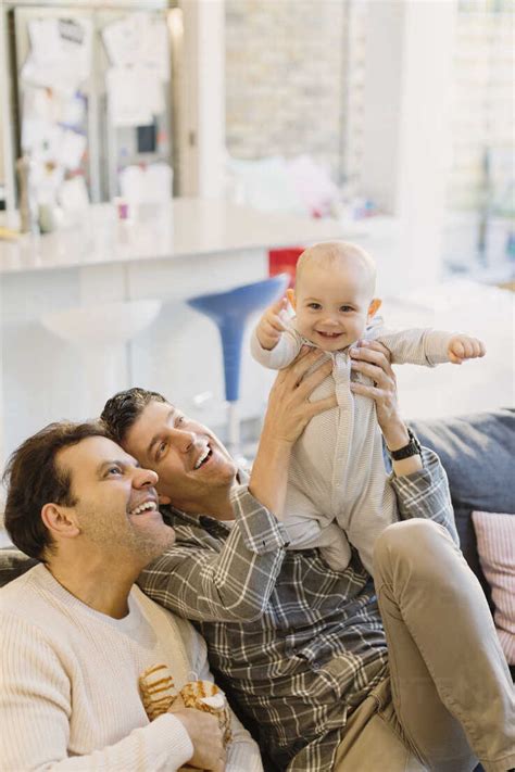 Portrait Playful Cute Baby Son With Male Gay Parents Stock Photo