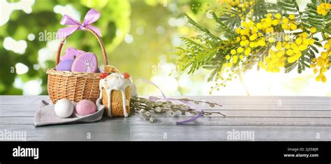 Easter Basket With Painted Eggs Cookies Pussy Willow Branches And Cake On Table Outdoors Stock
