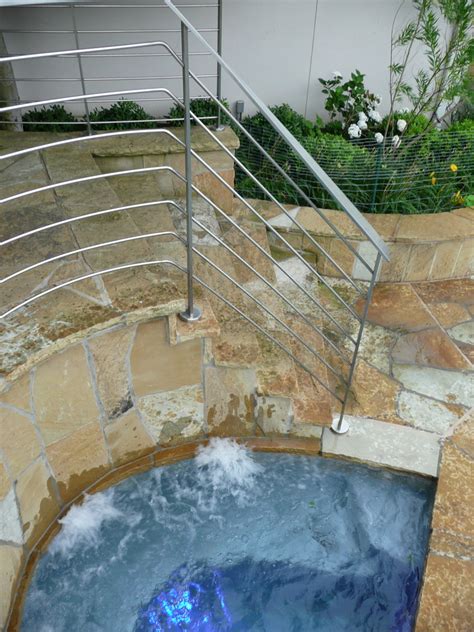 Hot Tub Nestled Between Staircase Built From Flagstone And Stainless