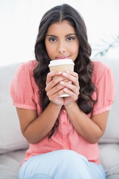 Premium Photo Calm Cute Brunette Sitting On Couch Holding Disposable Cup