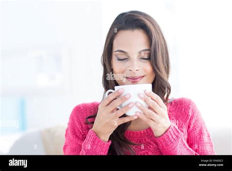 Smiling Beautiful Brunette Relaxing On The Couch And Holding Mug Stock Photo Alamy
