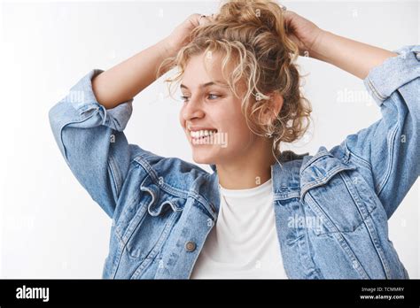 L insouciance joyeuse belle fille blonde fixant bun les mains derrière la tête de tourner à