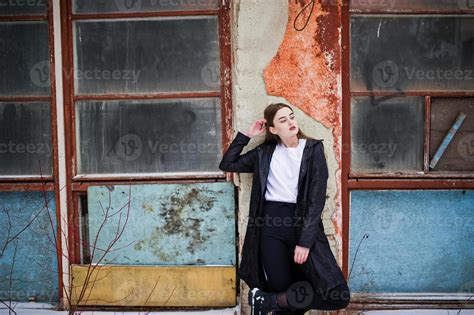 Fashionable Long Legs Brunette Model In Long Black Cloak Posed Outdoor At Winter Day Against Old