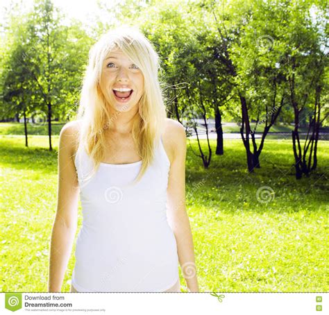 Marche De Sourire De Fille Blonde Mignonne Heureuse En Parc Vert