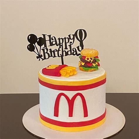 a birthday cake with a hamburger and fries on top is decorated to look ...