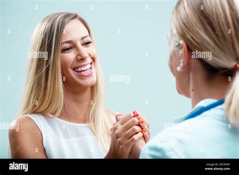 Blonde Ärztin mit ihrer Patientin sich körperlich und emotional um sie kümmert Ihre