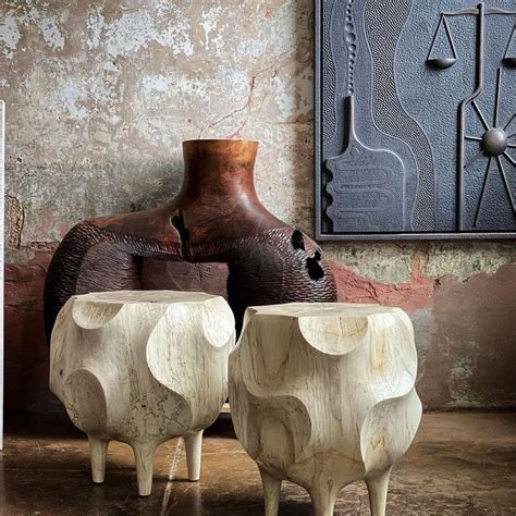 Two Wooden Stools Sitting Next To Each Other In Front Of A Painting On The Wall