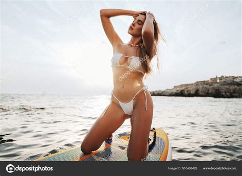 Sexy Tanned Girl In White Bikini Standing On SUP Board Stock Photo