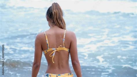 Beautiful Young Woman in Bikini Slowly Walking in the Ocean vídeo do Stock Adobe Stock