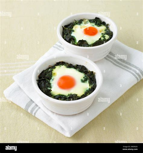 Baked eggs in spinach pots Stock Photo - Alamy