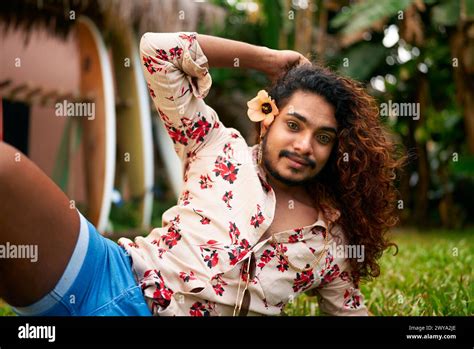 Gay Man With Floral Shirt Poses Holds Flower Exudes Confidence Style In Rich Garden Vibrant