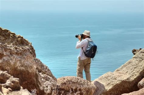 Tourist Photographing Nature Standing On The Edge Of A Cliff Stock