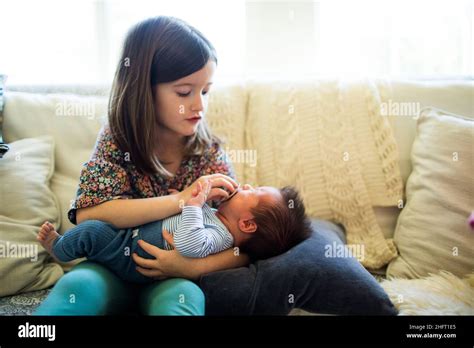 Big Sister Caring For Her Newborn Baby Brother Stock Photo Alamy