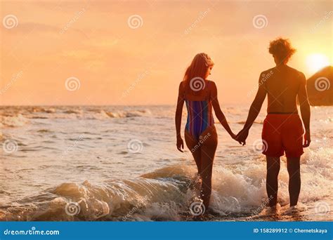 Une Jeune Femme En Bikini Et Elle Sur La Plage Au Coucher Du Soleil Joli Couple Photo Stock