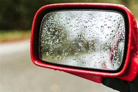 Gotas De Chuva No Espelho Lateral De Um Carro Vermelho Foto De Stock