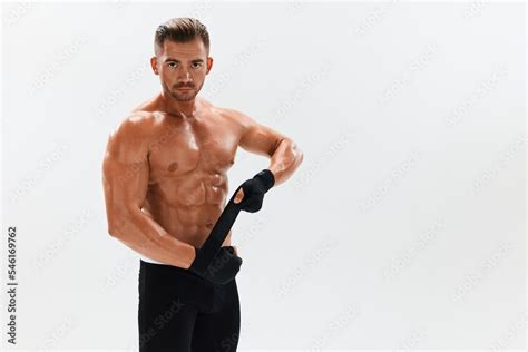 Man Athletic Bodybuilder Poses In Boxing Gloves With Nude Torso Abs In Full Length Background