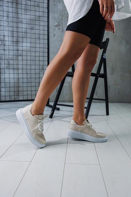 Premium Photo Female Slender Legs In Beige Casual Sneakers With Laces