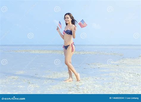 Muchacha Atractiva Asi Tica En El Bikini De La Bandera Americana Que Sostiene Una Peque A