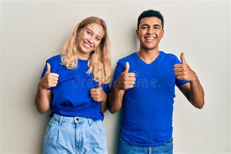 Young Interracial Couple Wearing Casual Clothes Success Sign Doing